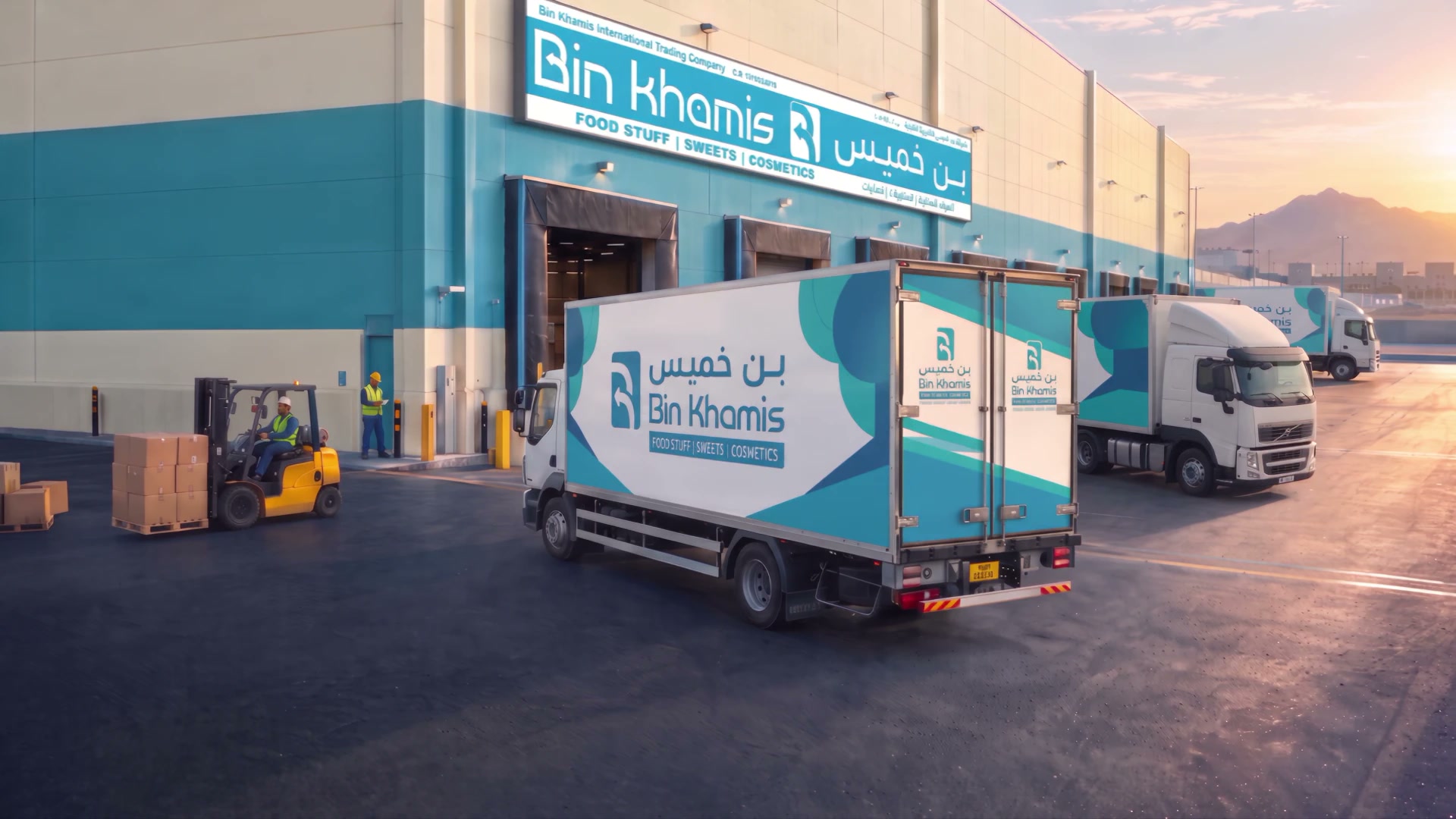 Bin Khamis warehouse yard at sunrise, with branded trucks at the dock